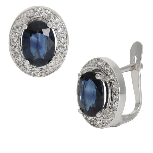 Pendientes en 100% Oro blanco de 18 Kl. con cerco de circonitas y zafiros finos. Cierre catalán