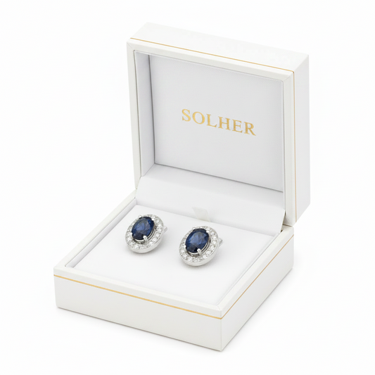 Pendientes en 100% Oro blanco de 18 Kl. con cerco de circonitas y zafiros finos. Cierre catalán